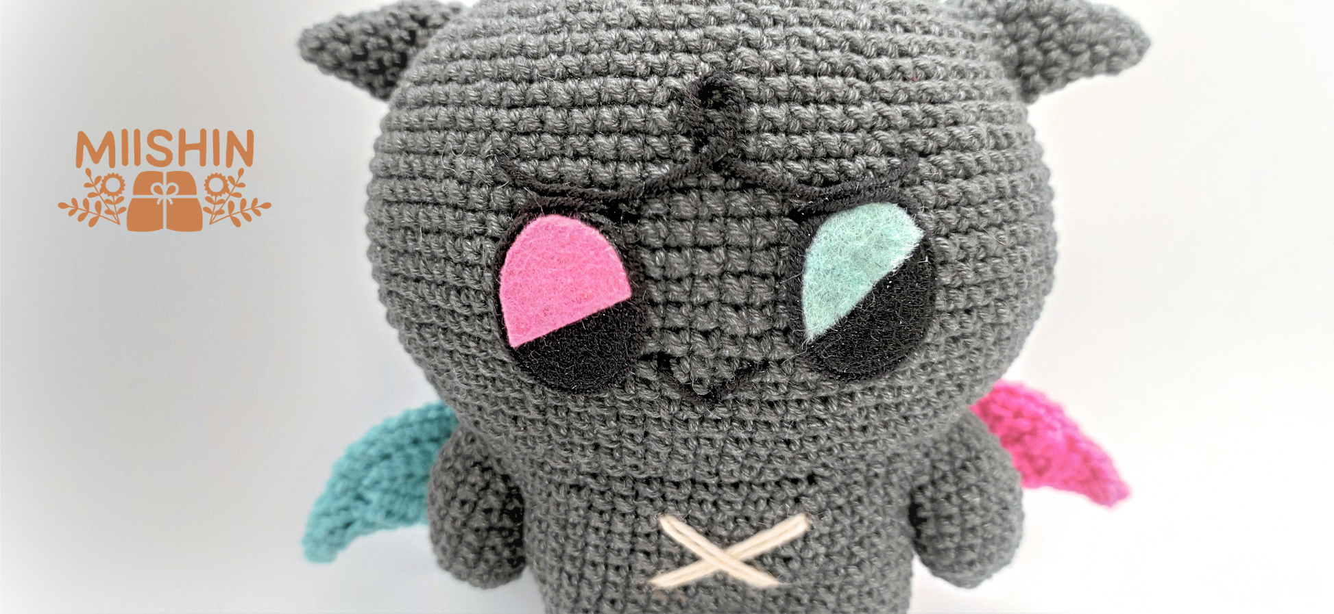 Vista ampliada del amigurumi Kkamyo mostrando los detalles en fieltro y bordados del peluche.