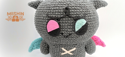 Vista ampliada del amigurumi Kkamyo mostrando los detalles en fieltro y bordados del peluche.