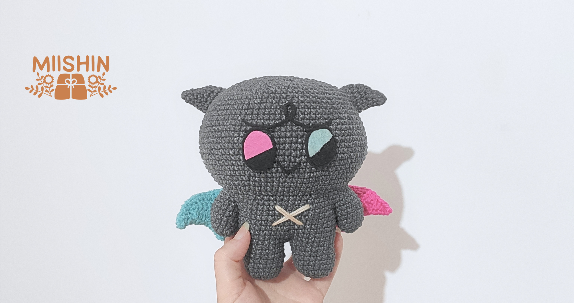 Se muestra al amigurumi Kkamyo sujetado en una mano y se aprecia el tamaño del peluche.