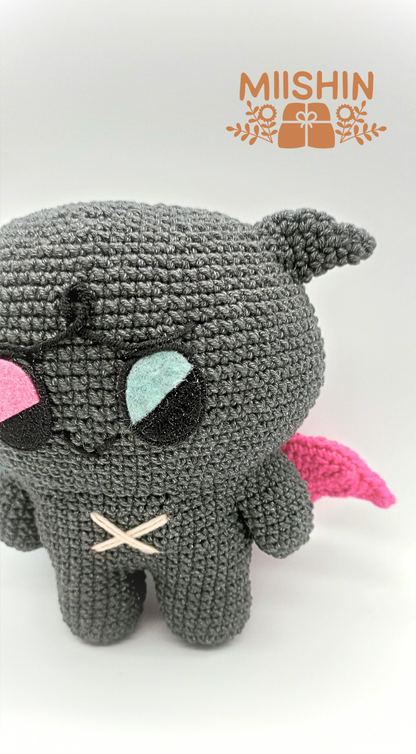 Vista ampliada del amigurumi Kkamyo mostrando los detalles en fieltro y bordados del peluche.