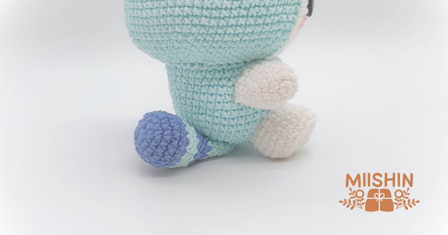 Vista ampliada del amigurumi Tasy mostrando el peluche sentado y descansando sobre su cola.