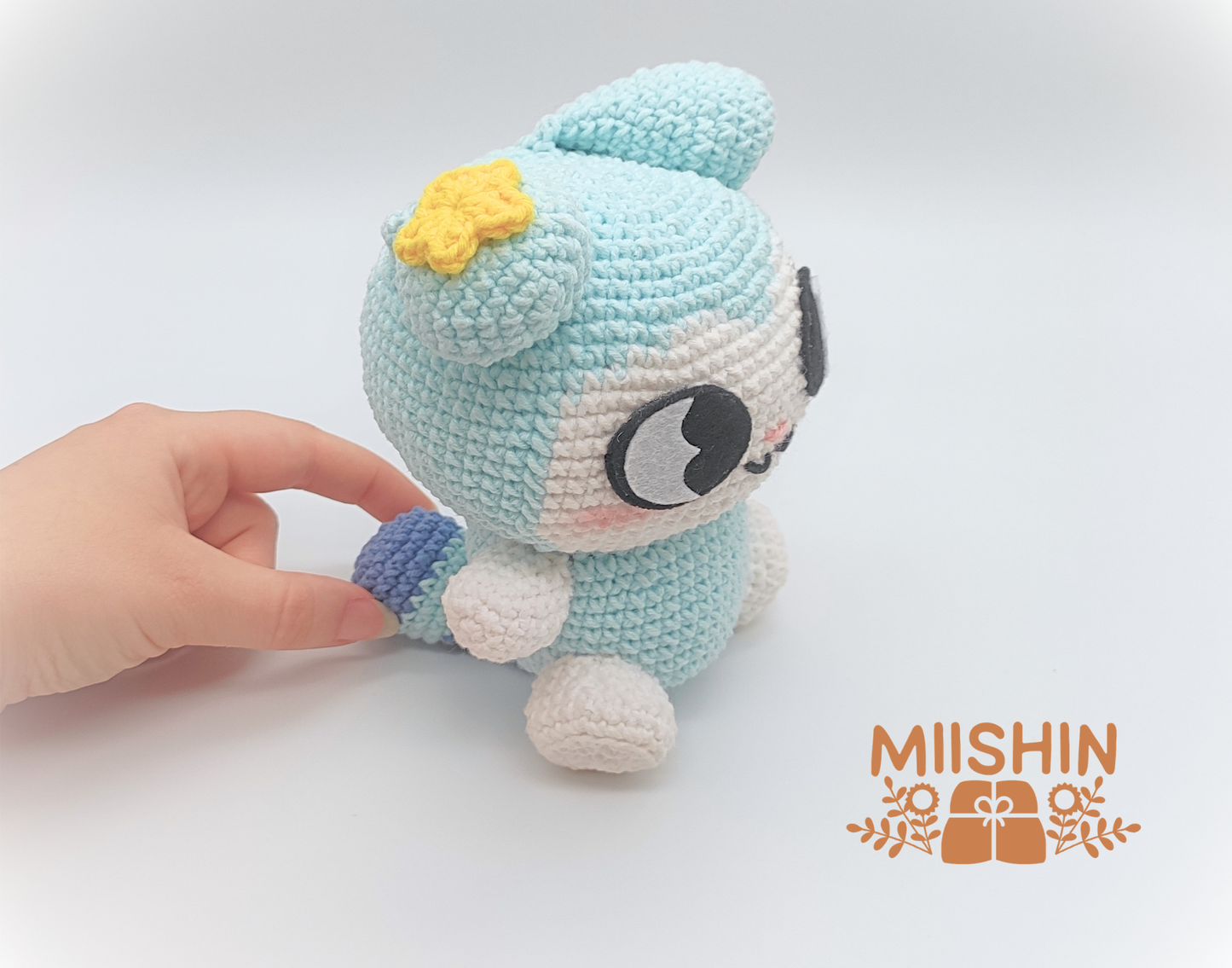 Se muestra al amigurumi Tasy sujetando con una mano la cola y se aprecia el tamaño del peluche.